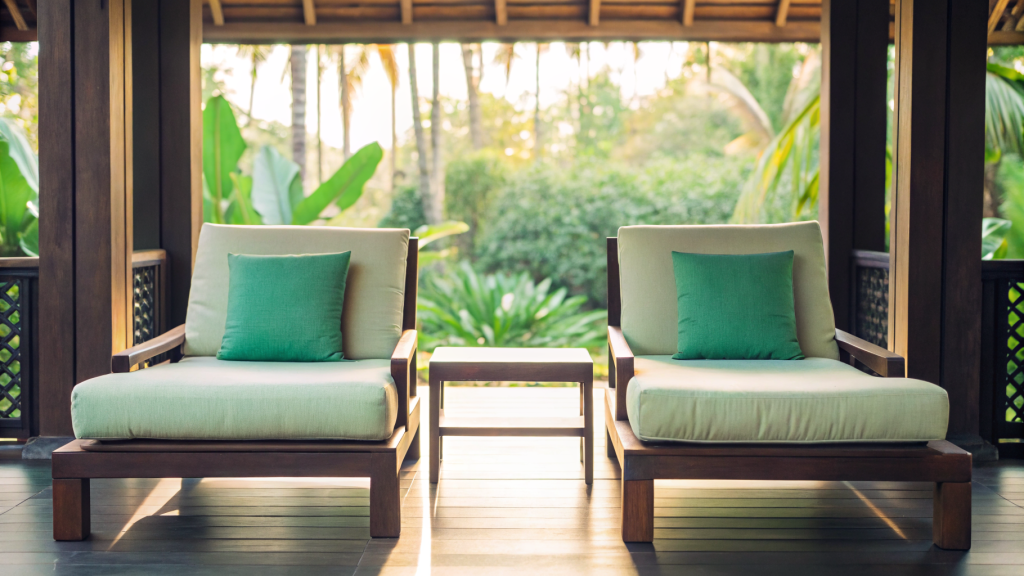 Two empty counselling chairs on a Thai retreat terrace overlooking a tropical garden